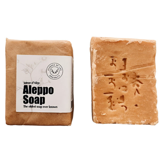 Essence of Life Organics Aleppo Soap, an all-natural, traditional olive and laurel oil soap, wrapped in eco-friendly packaging, with an unwrapped stamped bar beside it on a white background.