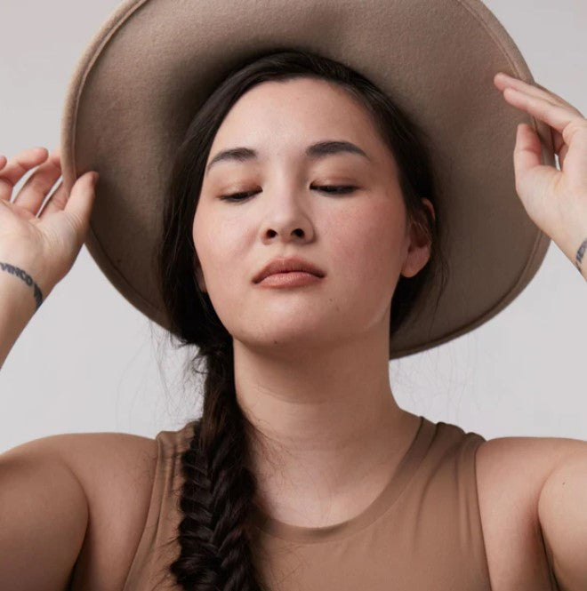 Close-up of the vacation mode lip & cheek tint tube with dewy bronze shimmer label, highlighting natural ingredients and