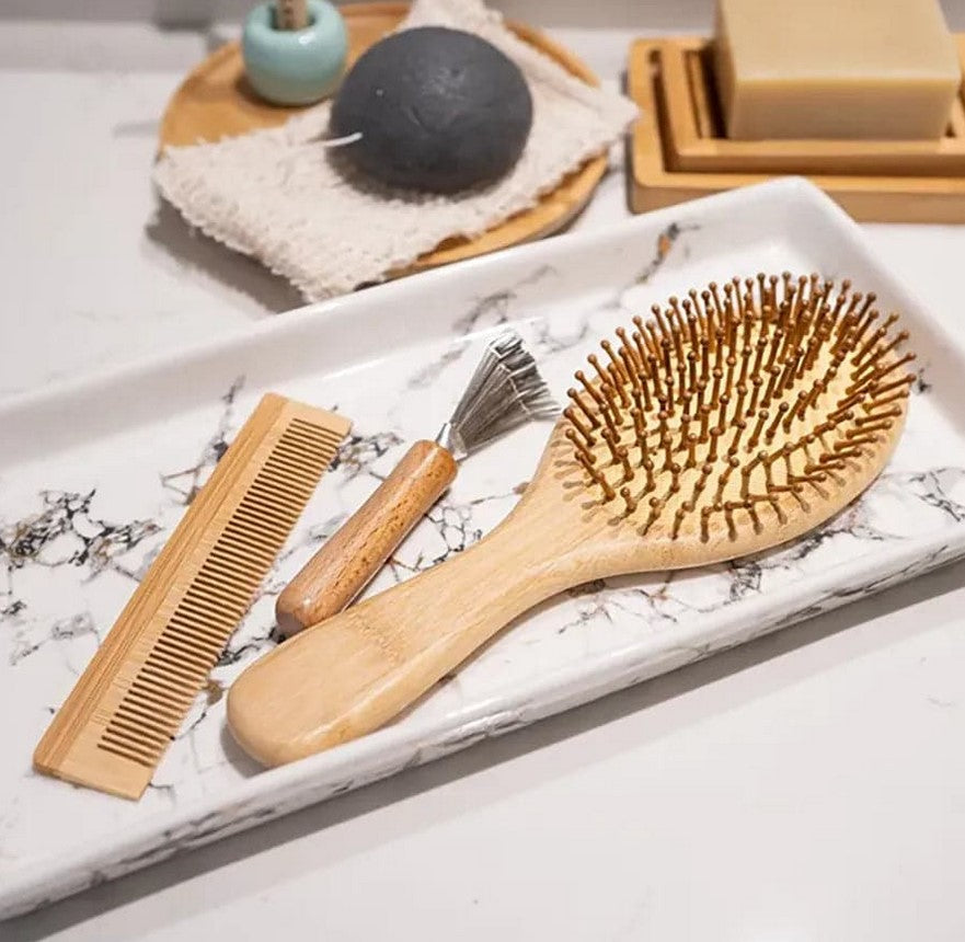 Plantish Bamboo Hair Brush Set with comb and brush cleaner displayed on marble bathroom tray – natural sustainable hair care set.