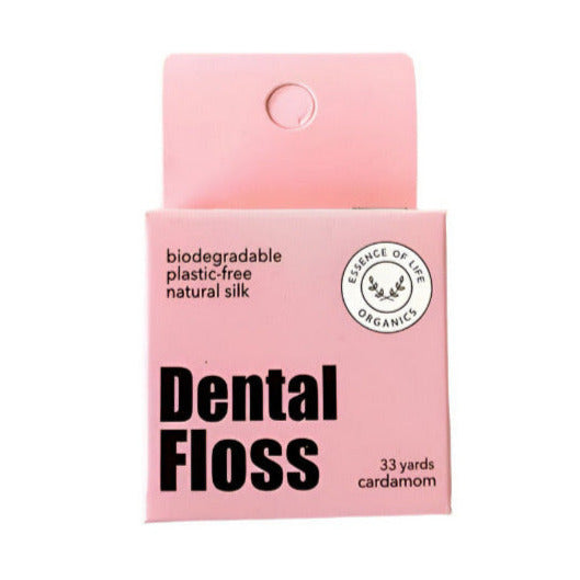 Essence of Life Organics biodegradable silk dental floss in a cardamon flavor, 33 yards, in a pink cardboard box with cutter on top, made in Canada. Shown on a white background.