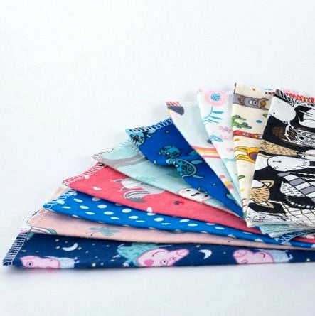 Set of 10 cloth napkins for kids by cheeks ahoy in mixed boys and girls patterns on a white background. This are super soft, fun and reusable and are handmade in Canada.