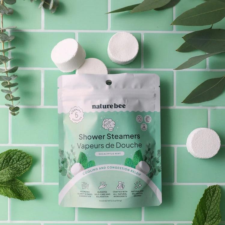A selection of individual eucalyptus mint shower steamers pictured coming out of its 5 pack resealable and compostable pouch.