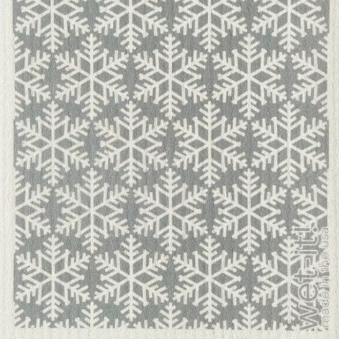 This Wet-it! Swedish dishcloth features white snowflakes on a grey background. It is made of high-grade cotton and cellulose pulp with a special weave that makes this reusable and compostable cloth highly absorbent - up to 16x it's weight!