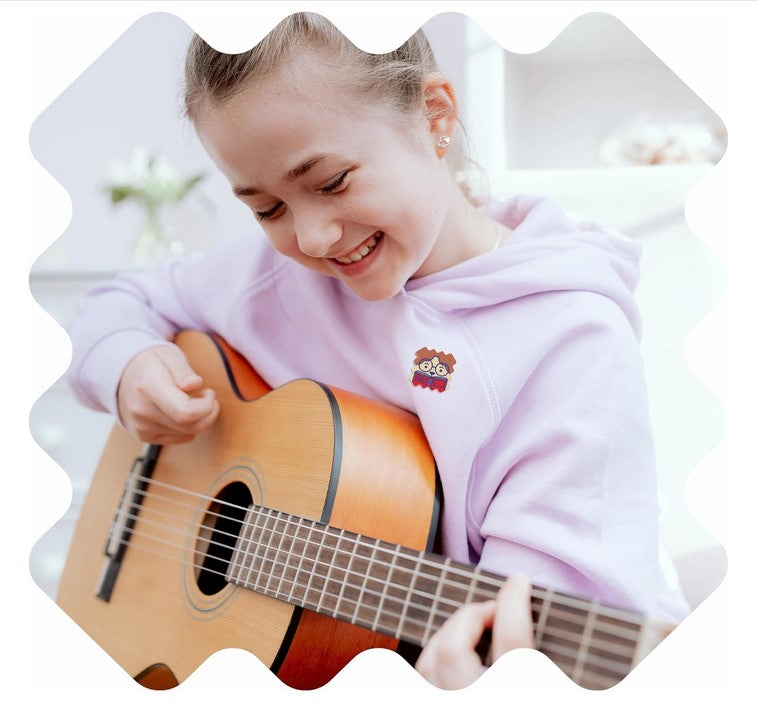 Girl wearing NatPat FocusPatch sticker while playing guitar – natural essential oil patches to support focus and alertness