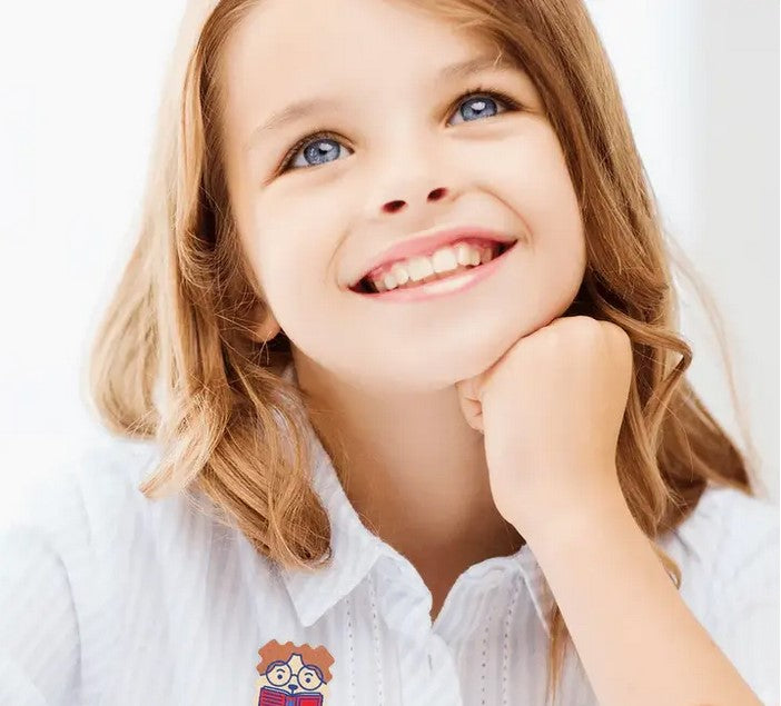 Girl with wearing NatPat FocusPatch sticker on her white blouse – natural non-medicated focus support for kids
