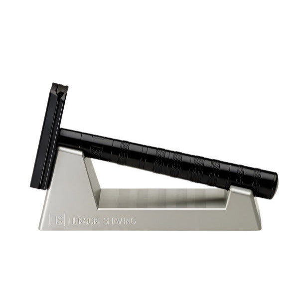 Matte black Henson Razor displayed in anodized aluminum razor stand