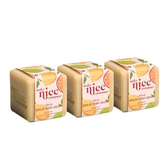 Three labelled citrus essential oil scented solid dish soap cubes weighing 240 g each sit side by side on a white background. This zero waste dish soap is made in Canada by the Make Nice Company