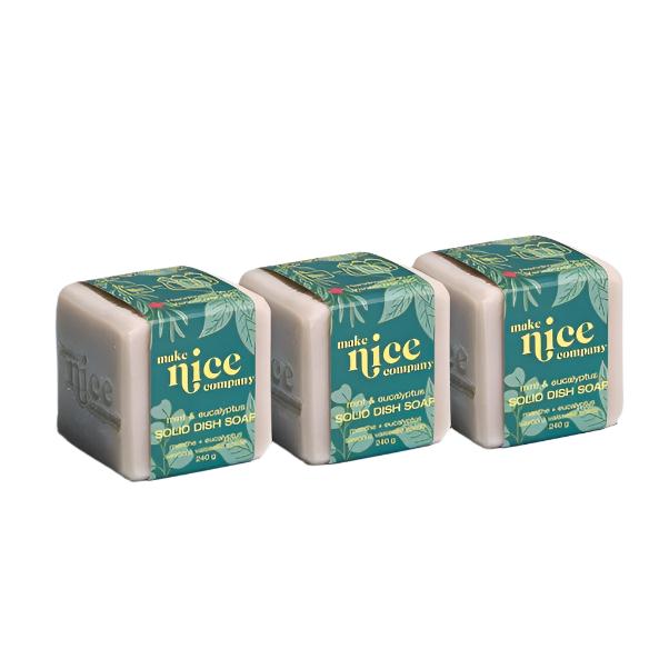 Three labelled mint eucalyptus essential oil scented solid dish soap cubes weighing 240 g each sit side by side on a white background. This zero waste dish soap is made in Canada by the Make Nice Company