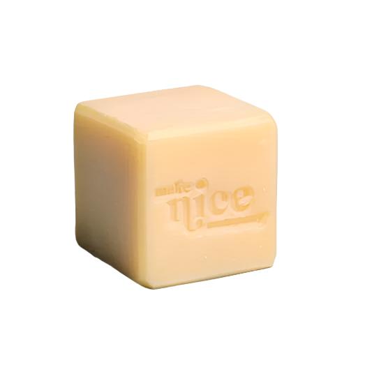 An unlabelled citrus scented solid dish soap cube 240 g made in Canada by the Make Nice Company with essential oils on a white background