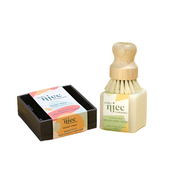 Included in this starter bundle is a regular unscented solid dish soap bar 240 g, a biodegradable wood scrubber brush and a square black 3D printed regular dish soap tray. All items are pictured on a white background.