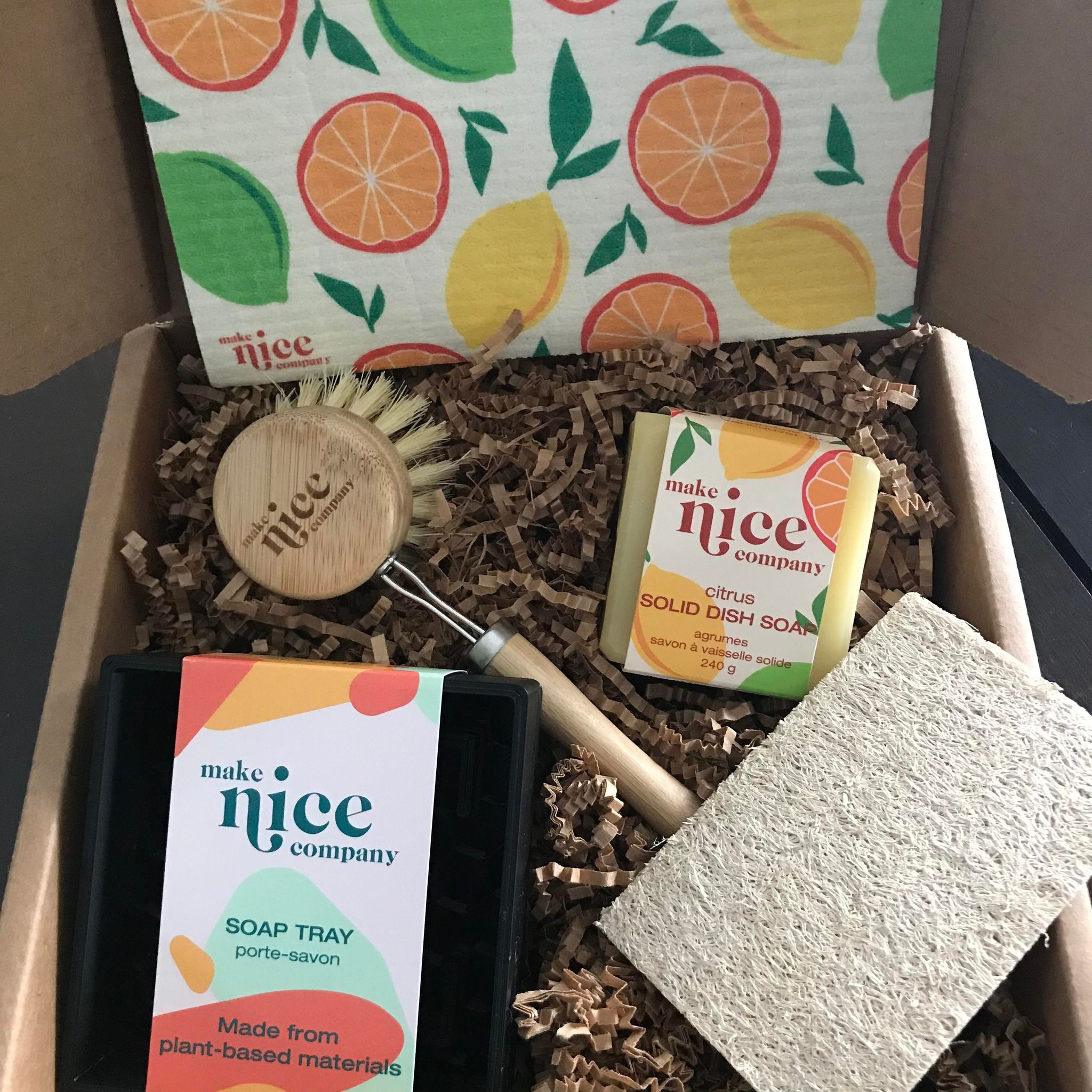 Citrus dish soap bar eco gift set made in Canada by the Make Nice Company includes a sponge cloth, a citrus solid dish soap cube, a dish brush, a plant=based soap tray and an expandable loofah sponge