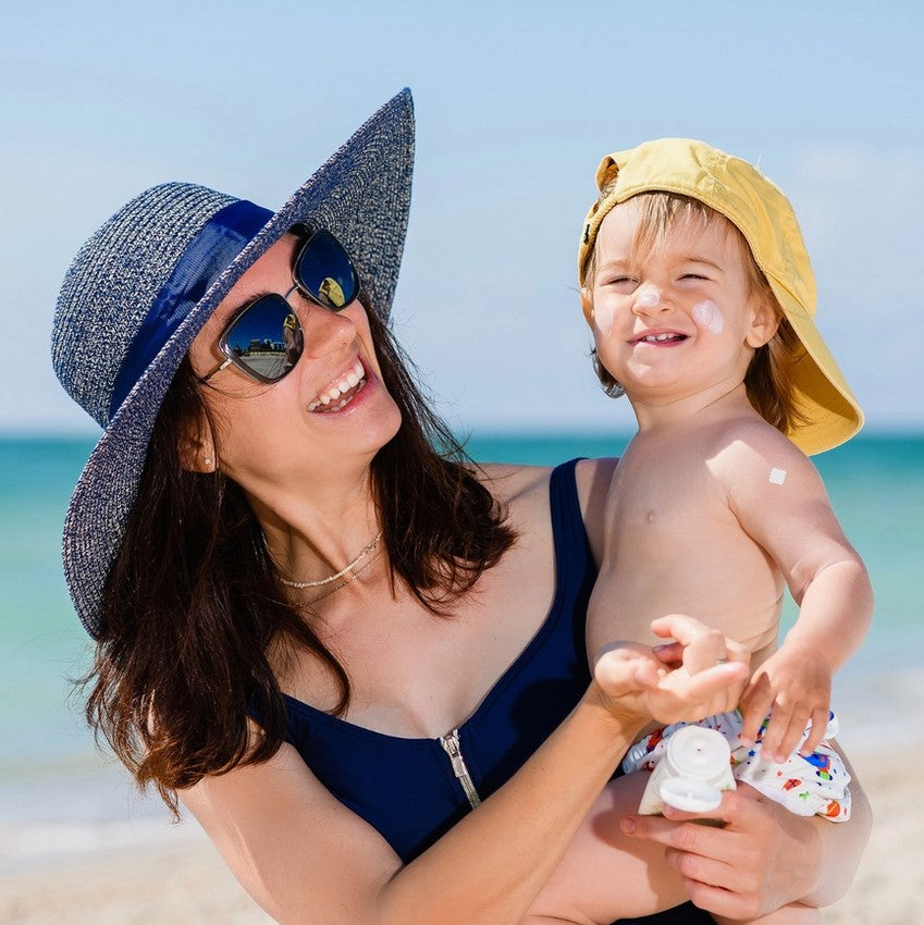 Woman and child on a beach with blue sky and ocean