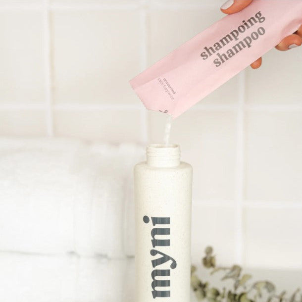 Canadian made shampoo powder being poured into a white 400 ml myni wheat straw bottle filled with 350 ml of water