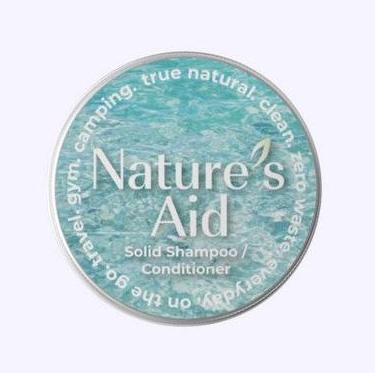 Close-up of the matte black travel tin with embossed "Nature's Aid" logo and textured surface for grip.
