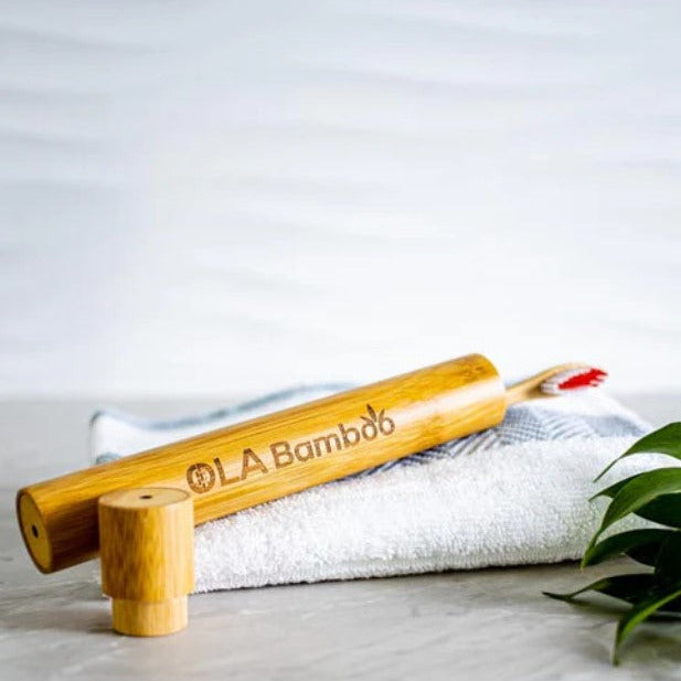 Bamboo toothbrush in Ola Bamboo travel case resting on folded towel