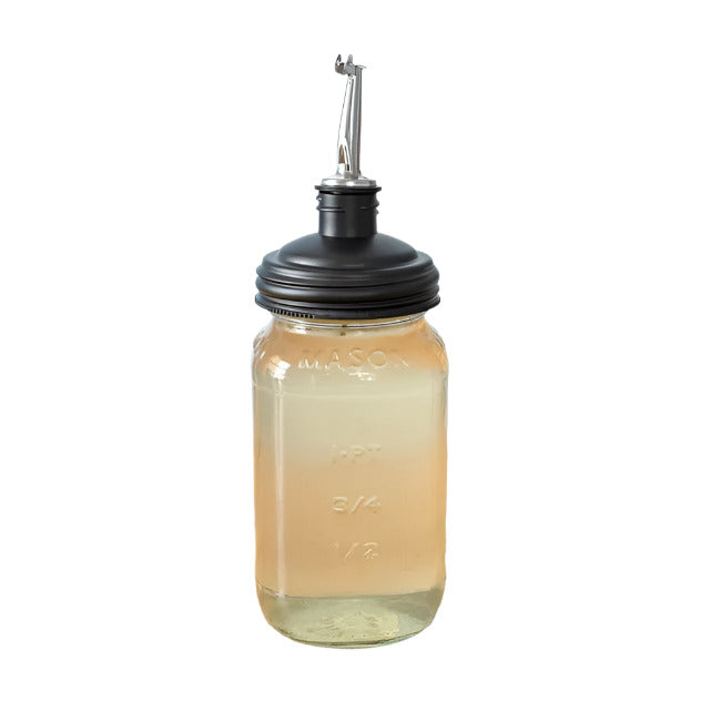 Mason jar with black reCAP® pour spout lid filled with dish soap on a white background