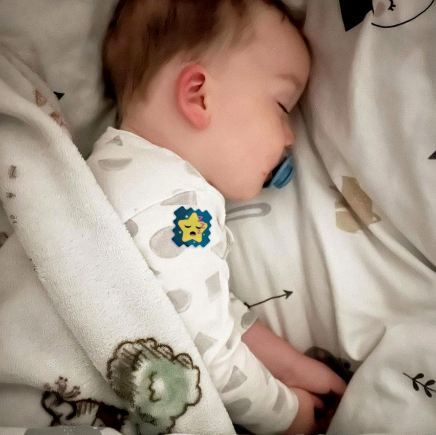 Baby sleeping in a crib with white bedding