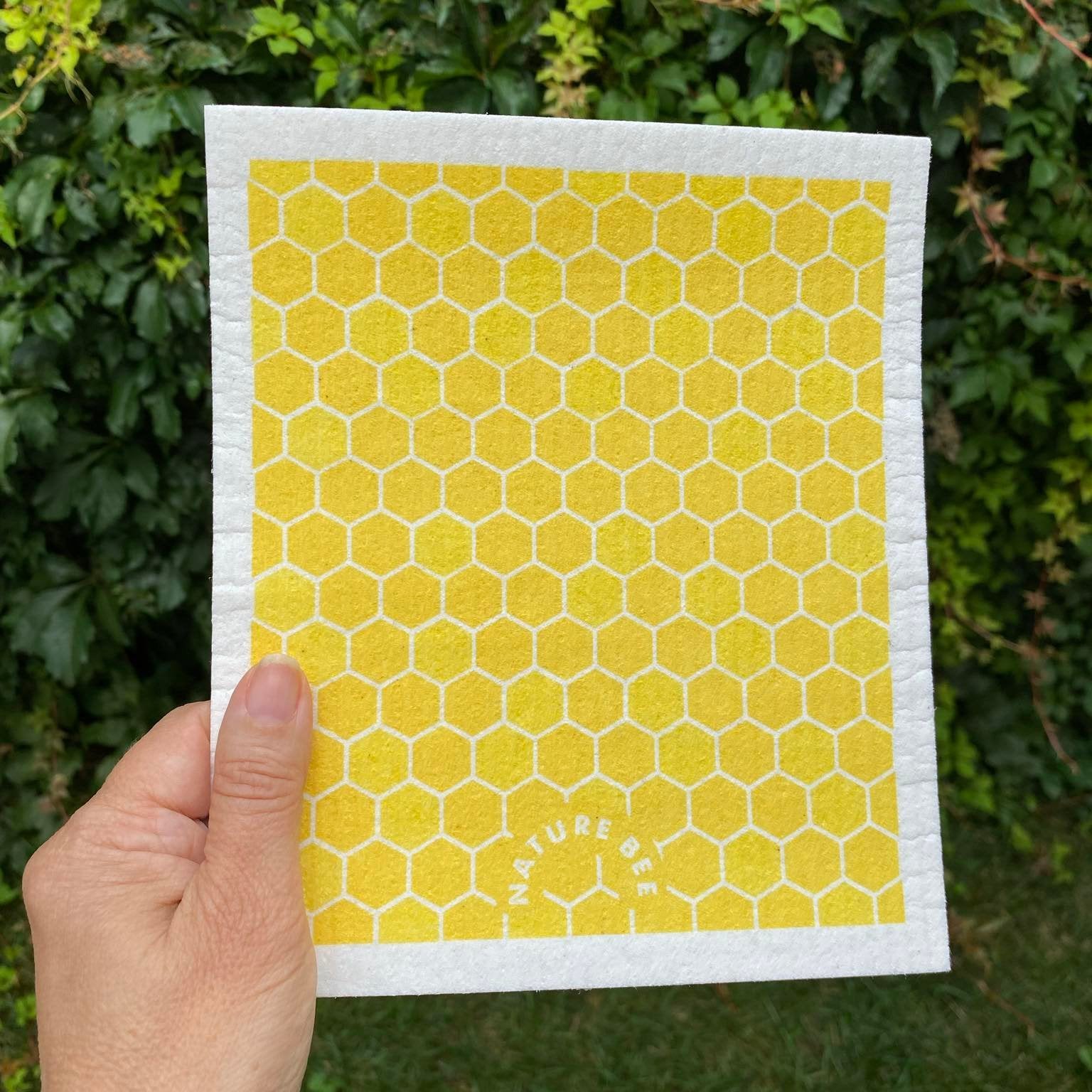 Swedish dishcloth in a yellow honeycomb pattern by Nature Bee replaces 17 paper towel rolls and absorbs up to 20x its weight in liquid