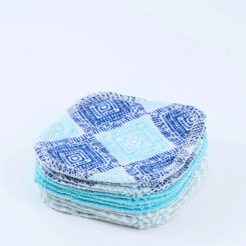 Stack of blue and white patterned fabric pads on a light gray background