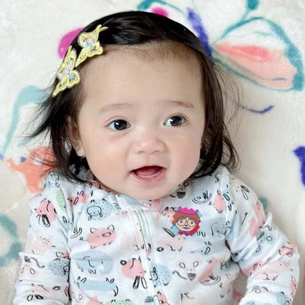 Smiling toddler wearing NATPAT Breathe Easy Vapor Sticker on pajamas for safe natural congestion relief