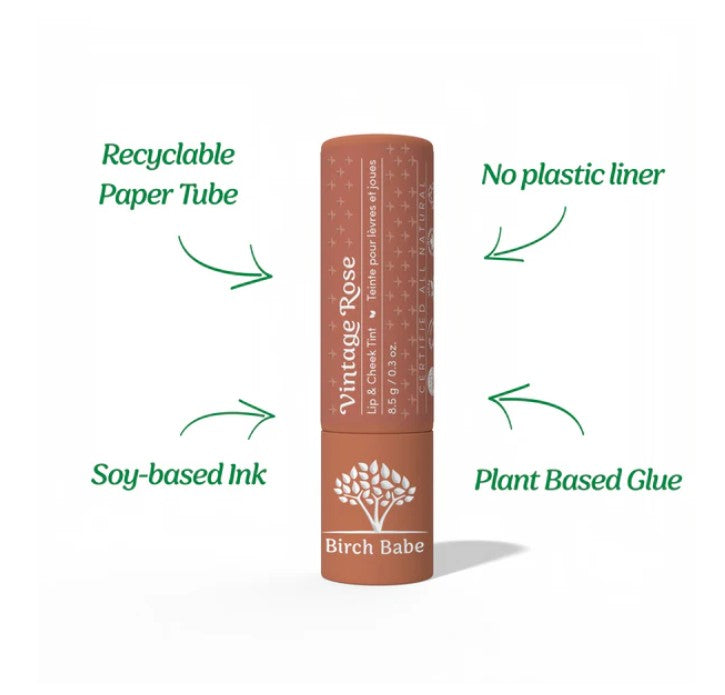 Close-up of the Vintage Rose Lip & Cheek Tint tube displaying the matte texture and soft rose scent label, showing product