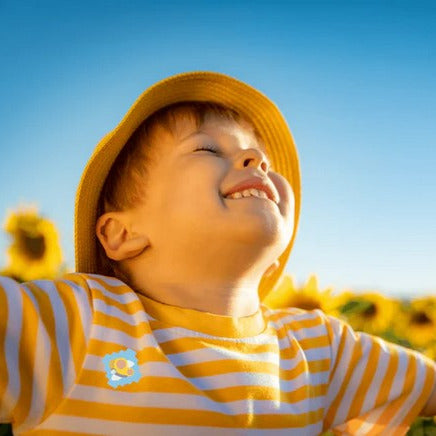 Young boy enjoying fresh air while wearing NATPAT StuffyPatch Breathe Easy Sticker for natural allergy and cold relief