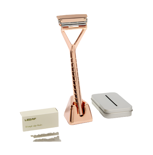 Rose Gold Leaf Razor Kit with pivoting metal razor, stand, blade recycling tin, and 50 single-edge razor blades displayed on a white background.