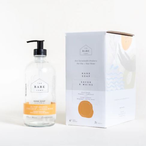 Blood Orange, Bergamot Lime and Sandalwood essential oil scented natural hand soap in a 476 ml refillable glass pump bottle sits alongside a 3 L at home refill box both of which are made in Canada by The Bare Home company based in Ontario