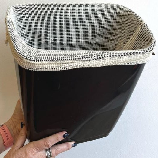 Large 17"x 14" organic cotton mesh laundry bag shown lining a kitchen or bathroom laundry bin
