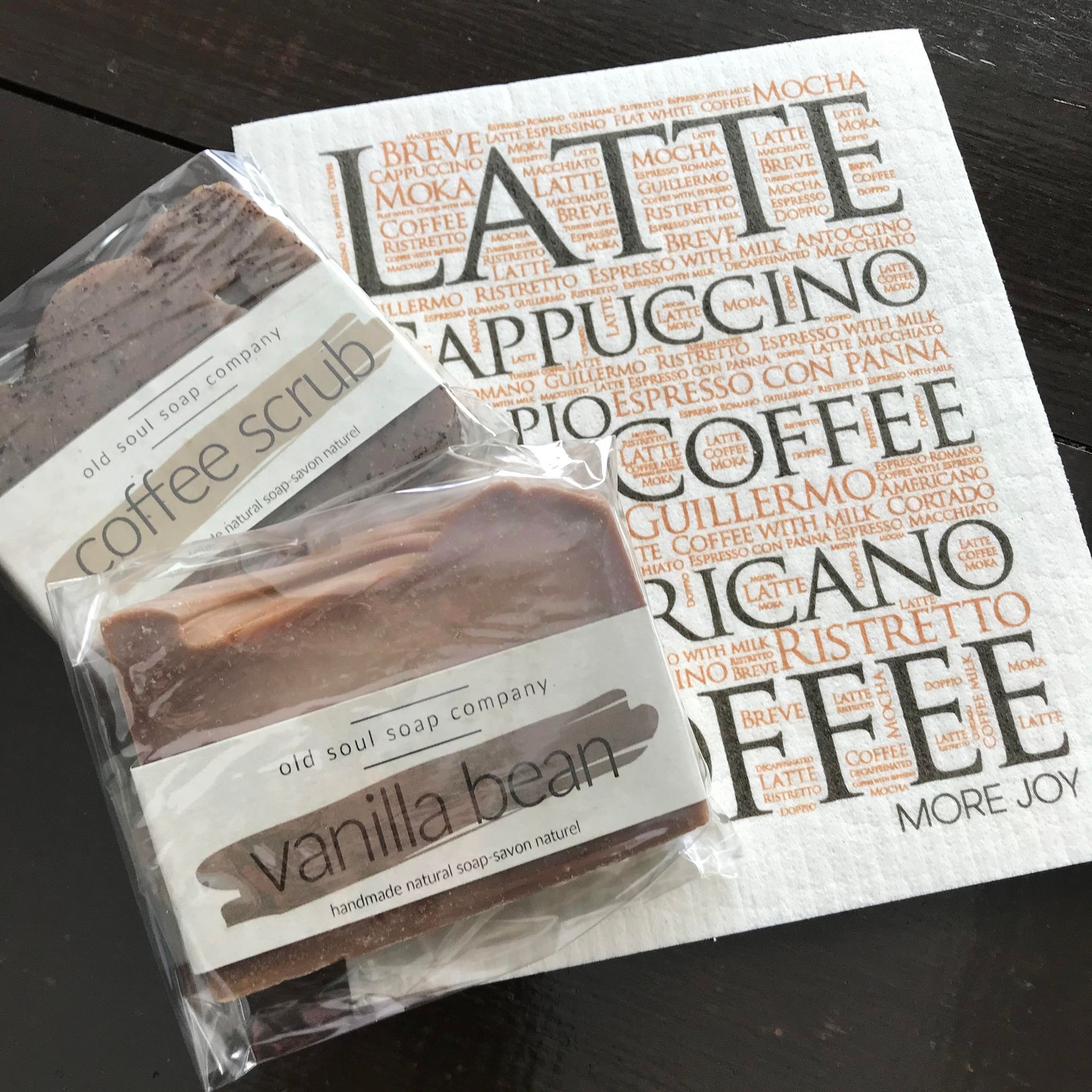 Featured in this coffee gift set are two handcrafted bars of artisan soap - coffee scrub and vanilla bean as well as a Coffee themed Swedish cloth by More Joy