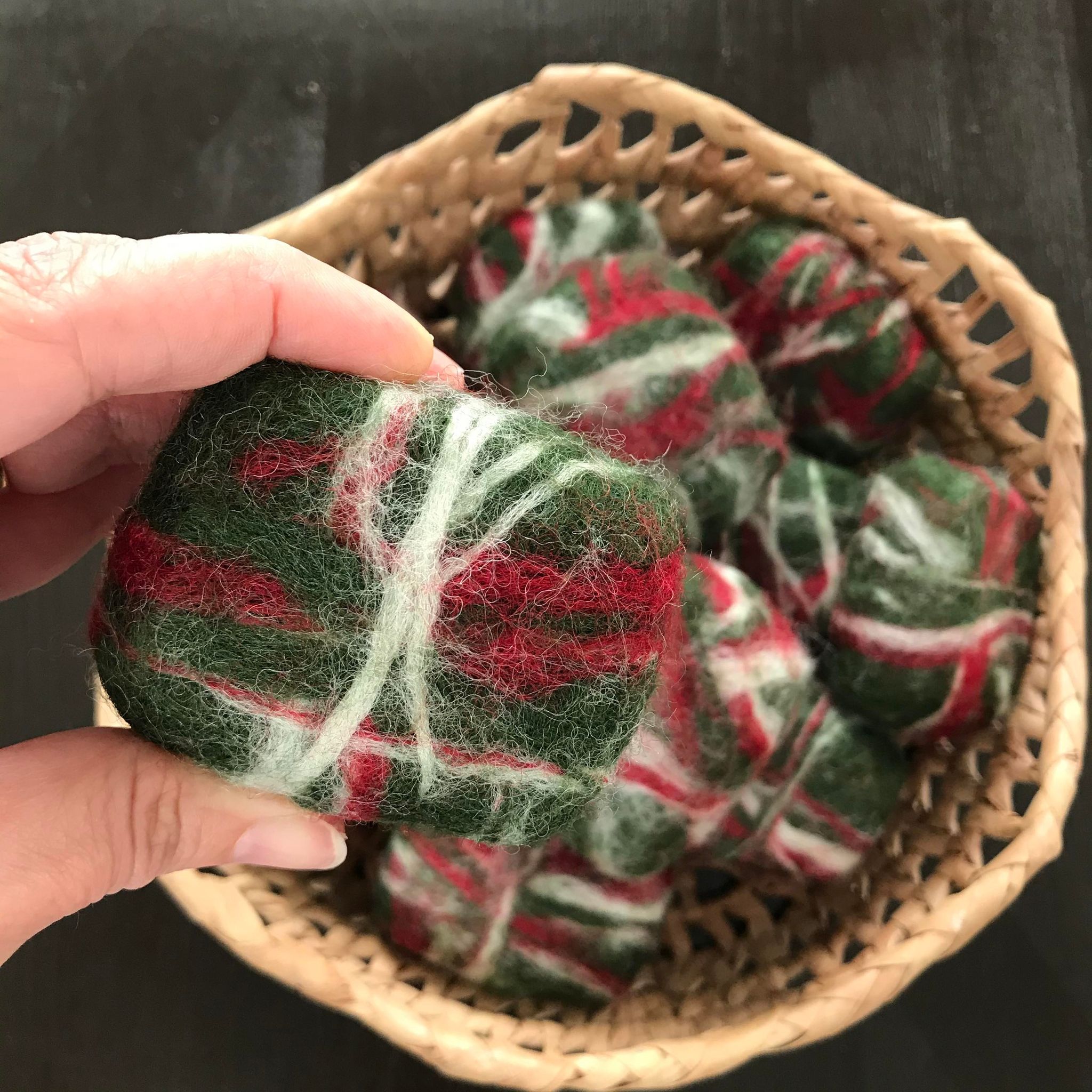 A basket of cedar fir wine guest soaps made in Canada by Simply Natural Canada and hand felted in shades of red, white and green