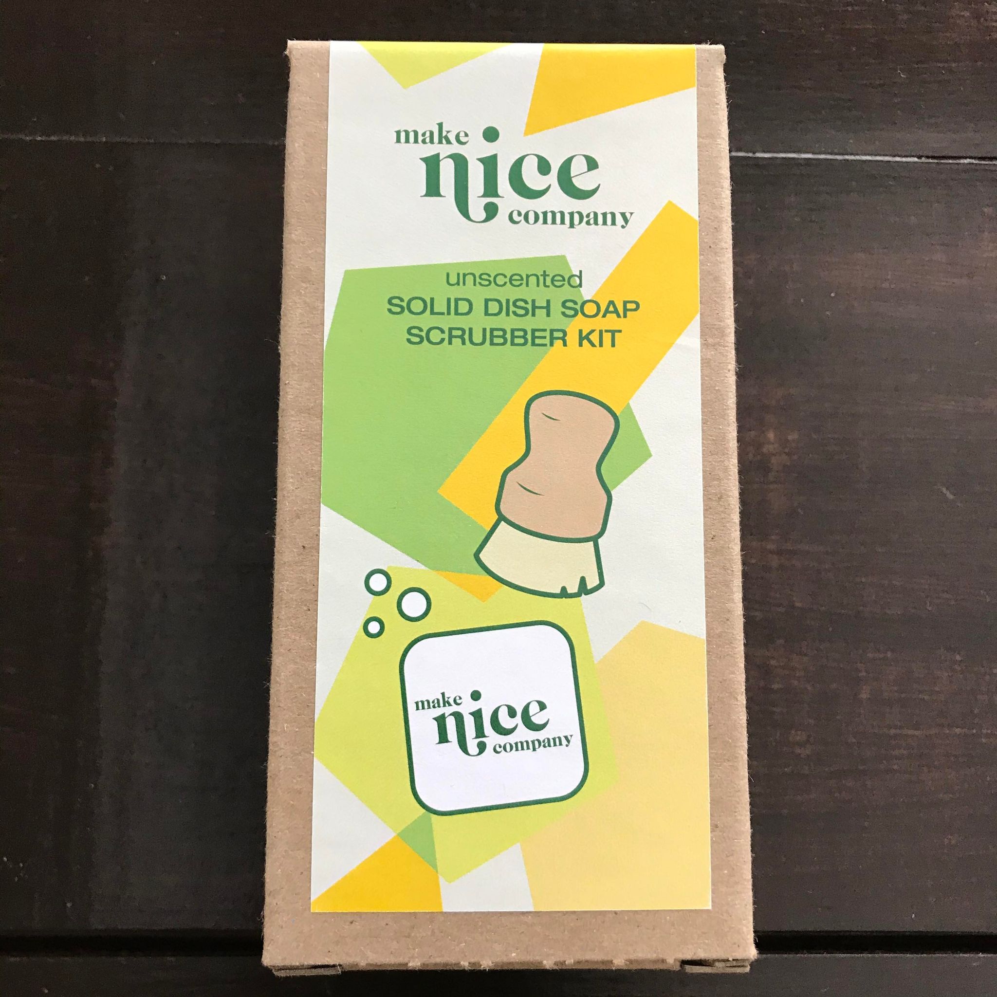 Unscented solid dish soap block and wood pot scrubber brush set made in Canada by the Make Nice Company and packaged in a brown cardboard box