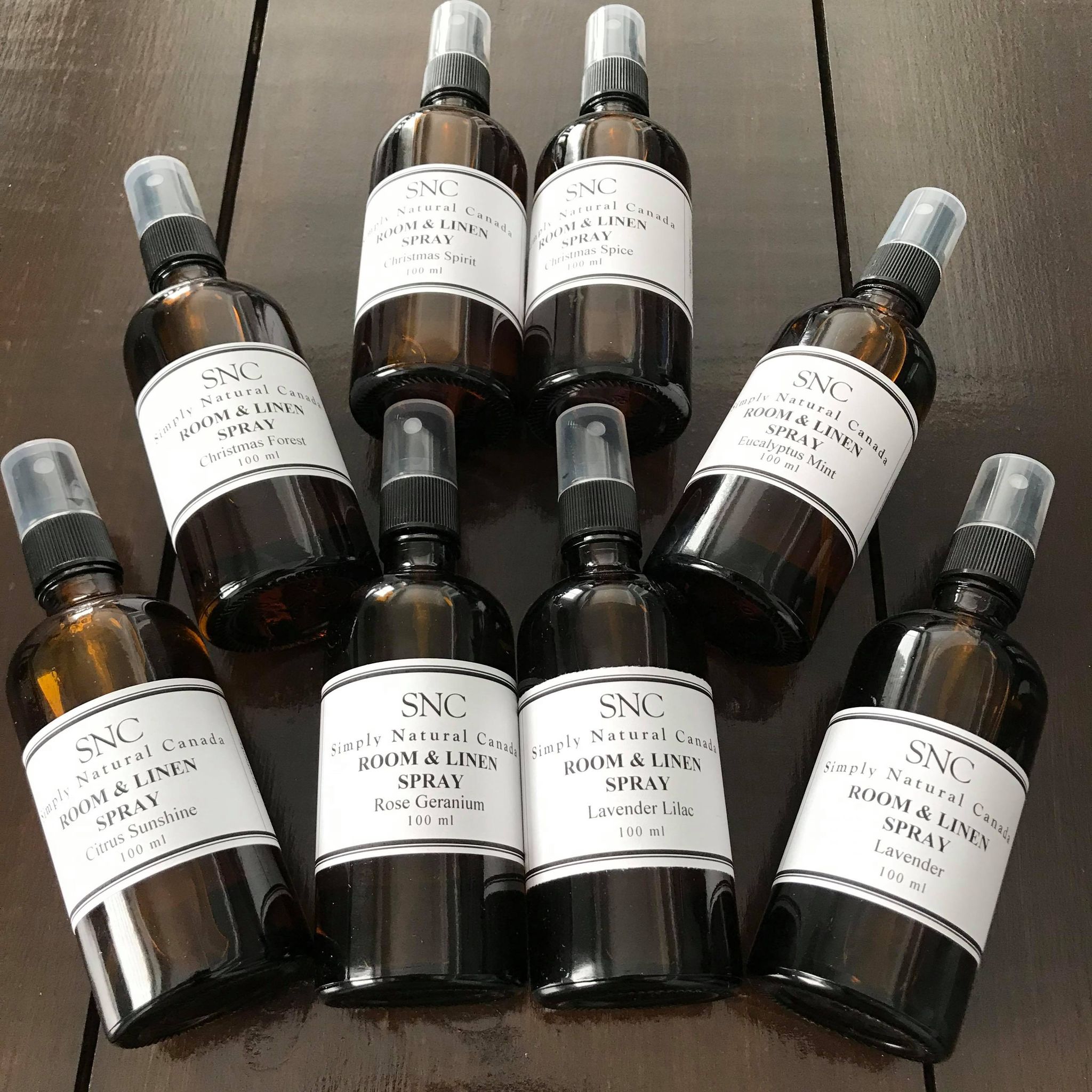 the simply natural canada natural essential oil room and linen spray collecition each scent is in a 100 ml amber glass bottle with black sprayer and has a black and white paper label
