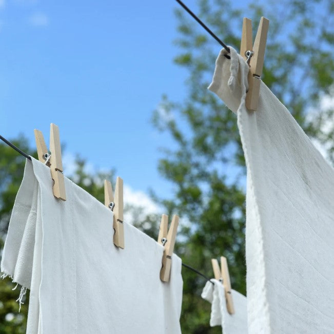 white fabric hanging from a clothes line washed with eco friendly laundry detergent