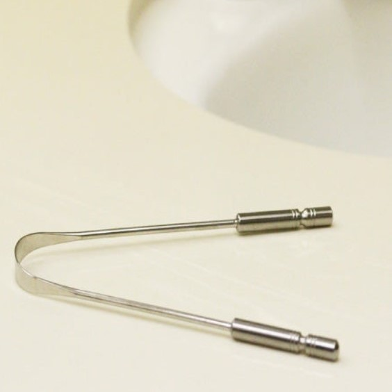 Stainless steel tongue cleaner on counter