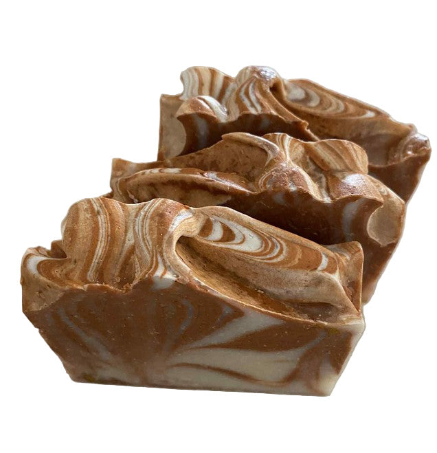 Three swirled brown and beige Canadian made autumn themed handcrafted soap bars on a white surface