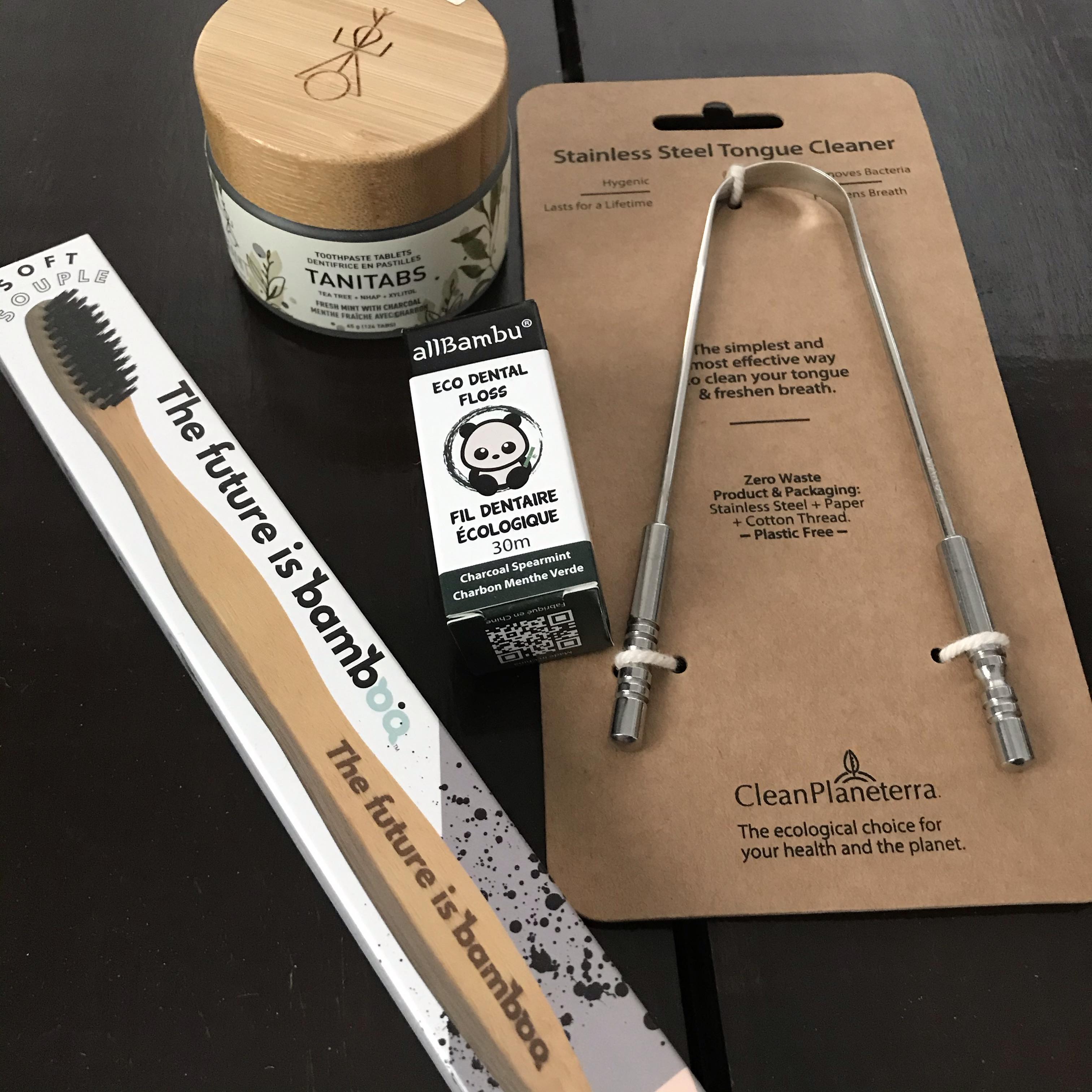 Included in this eco oral care kit is a soft charcoal bamboo toothbrush from The future is bamboo, a charcoal eco dental floss in a glass tube from allBambu, a glass jar of Tanitabs 124 fresh mint with charcoal toothpaste tablets from Tanit Botanics and a Stainless Steel Tongue Cleaner from Clean Planeterra