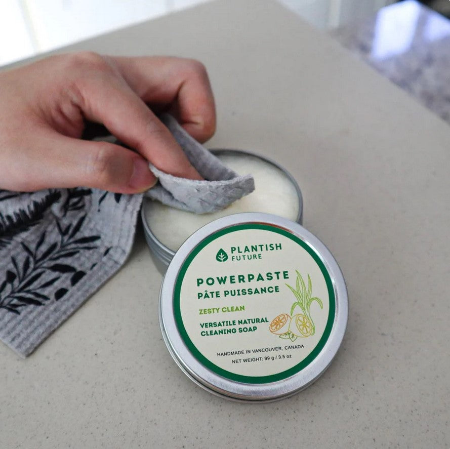 Hand using Plantish Powerpaste natural cleaning soap with sponge cloth – sustainable plant-based cleaner for kitchen and bathroom messes.