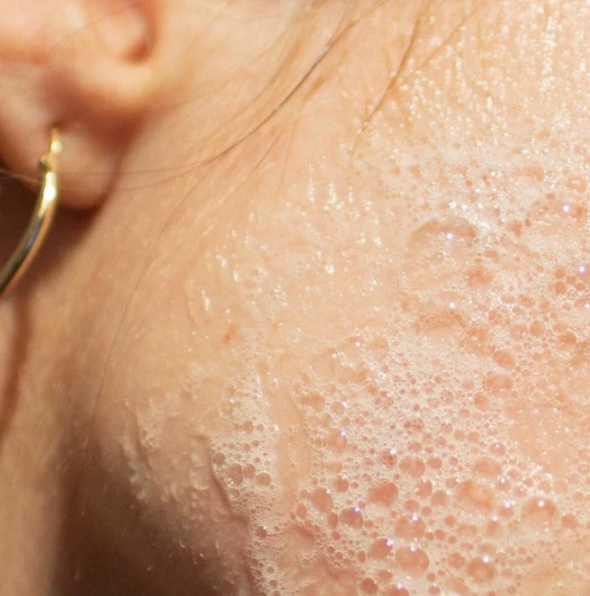 Birch babe facial cleansing bar shown in use on a woman's face