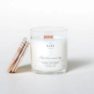This 'About that summer day' coconut and soy candle scented with lavender and sage essential oils is made in Canada by The Bare Home and features a wooden wick and a wooden lid. It is pictured on a white background with the lid off.