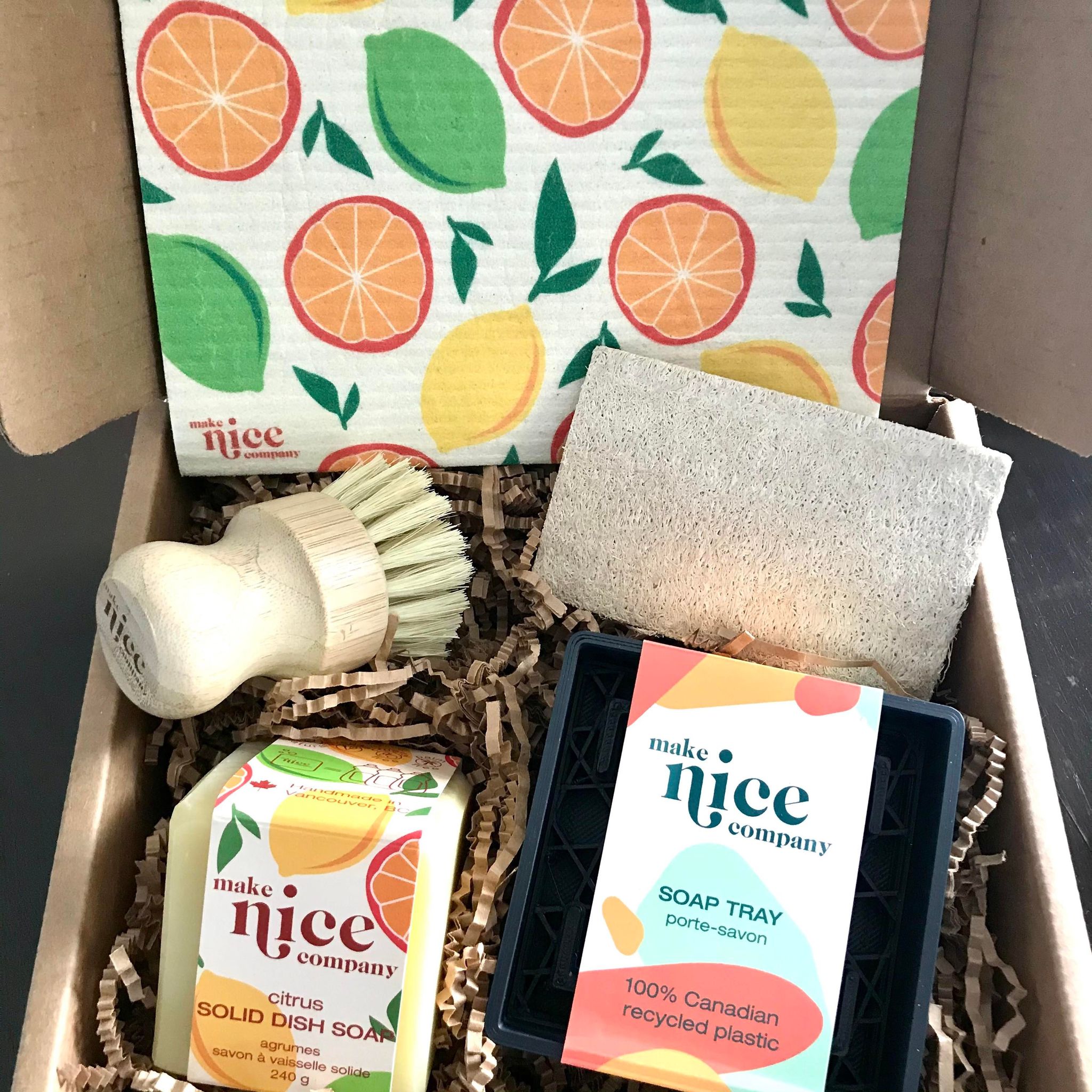 Citrus dish soap bar eco gift set made in Canada by the Make Nice Company includes a sponge cloth, a citrus solid dish soap cube, a dish brush, a recycled plastic soap tray and an expandable loofah sponge