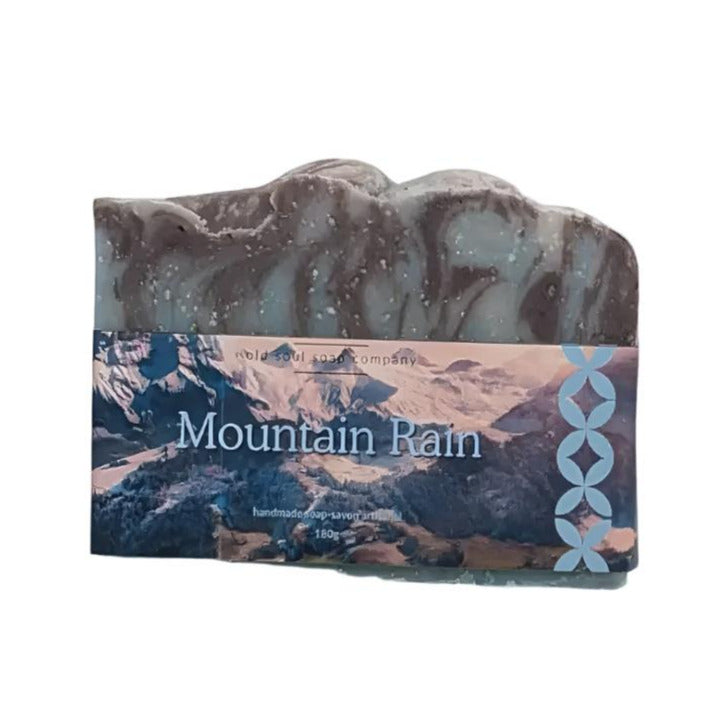 Artisan top fragrance 180 g bar soap with photo label with mountains and the words Mountain Rain. Soap is on a white background.