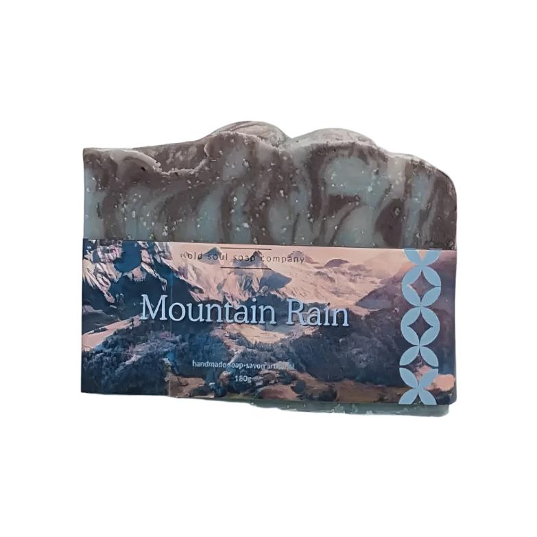 Artisan top fragrance 180 g bar soap with photo label with mountains and the words Mountain Rain. Soap is on a white background.