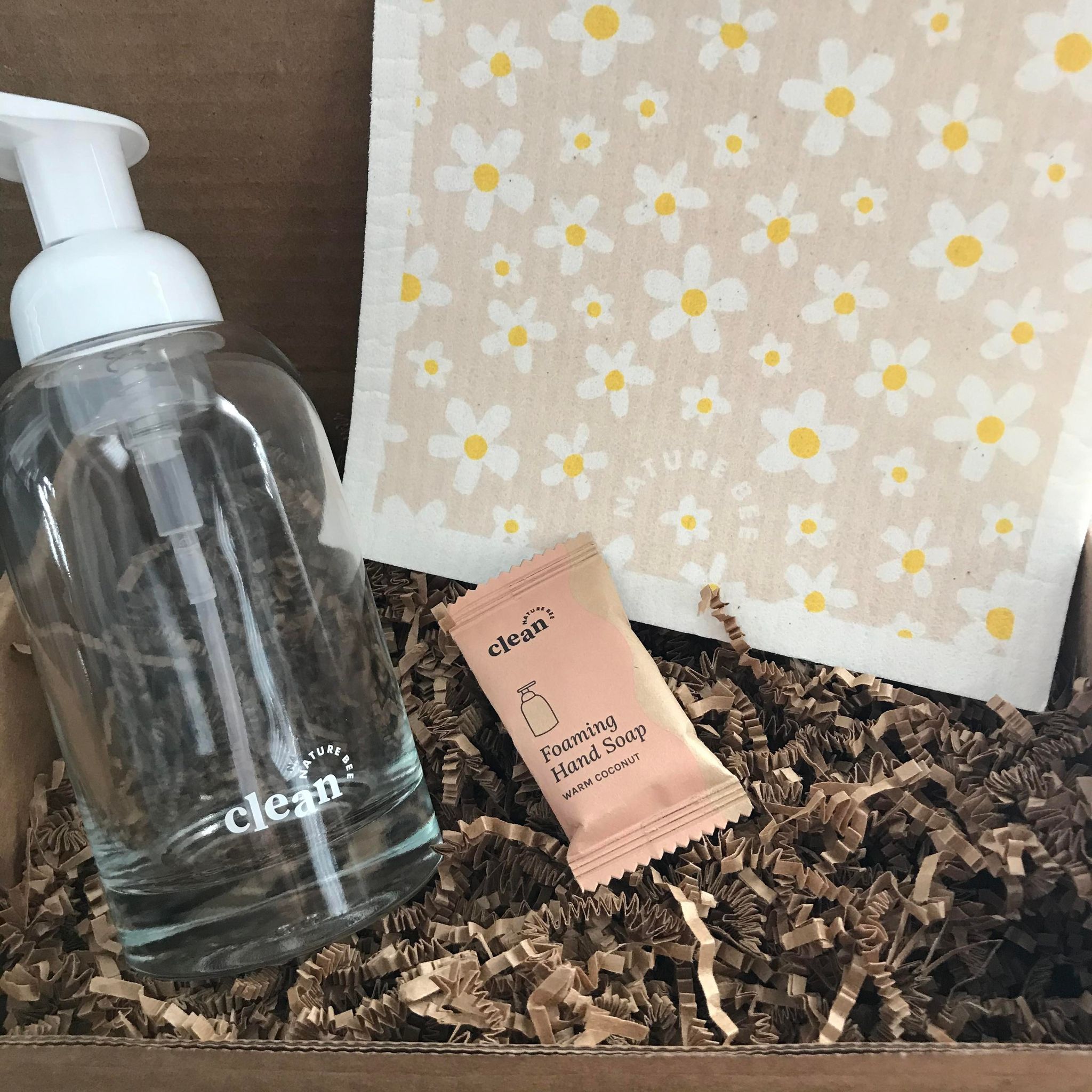 Included in this warm coconut hand soap kit is Swedish sponge cloth in a white daisy pattern, a foaming hand soap tablet and a refillable glass soap dispenser.