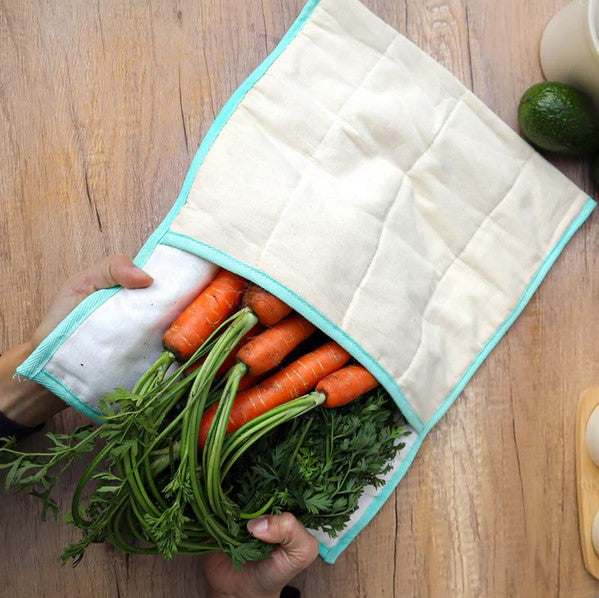 This Produce Saver Bag by Plantish is 42 cm x 52 cm (with flap open) and is made from all-natural, unseeded, and unbleached cotton designed to pull away excess moisture while keeping produce hydrated and free from toxic chemicals. This eco-friendly solution helps extend the freshness of your fruits and veggies for up to 14 extra days and is pictured with a bunch of carrots coming out of it.