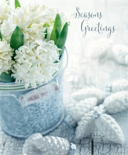 Bring a touch of the holidays into your home with this Season's Greetings Swedish Dishcloth by More Joy featuring the phrase "Seasons Greeting' and a blossoming white plant and white cone tree ornaments.