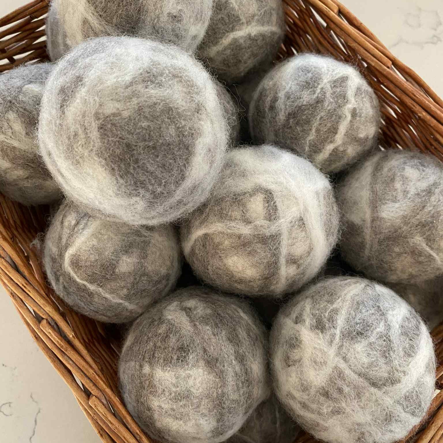 Basket of handcrafted Canadian XL wool dryer balls – eco-friendly laundry alternative to dryer sheets, made from 100% corriedale wool.