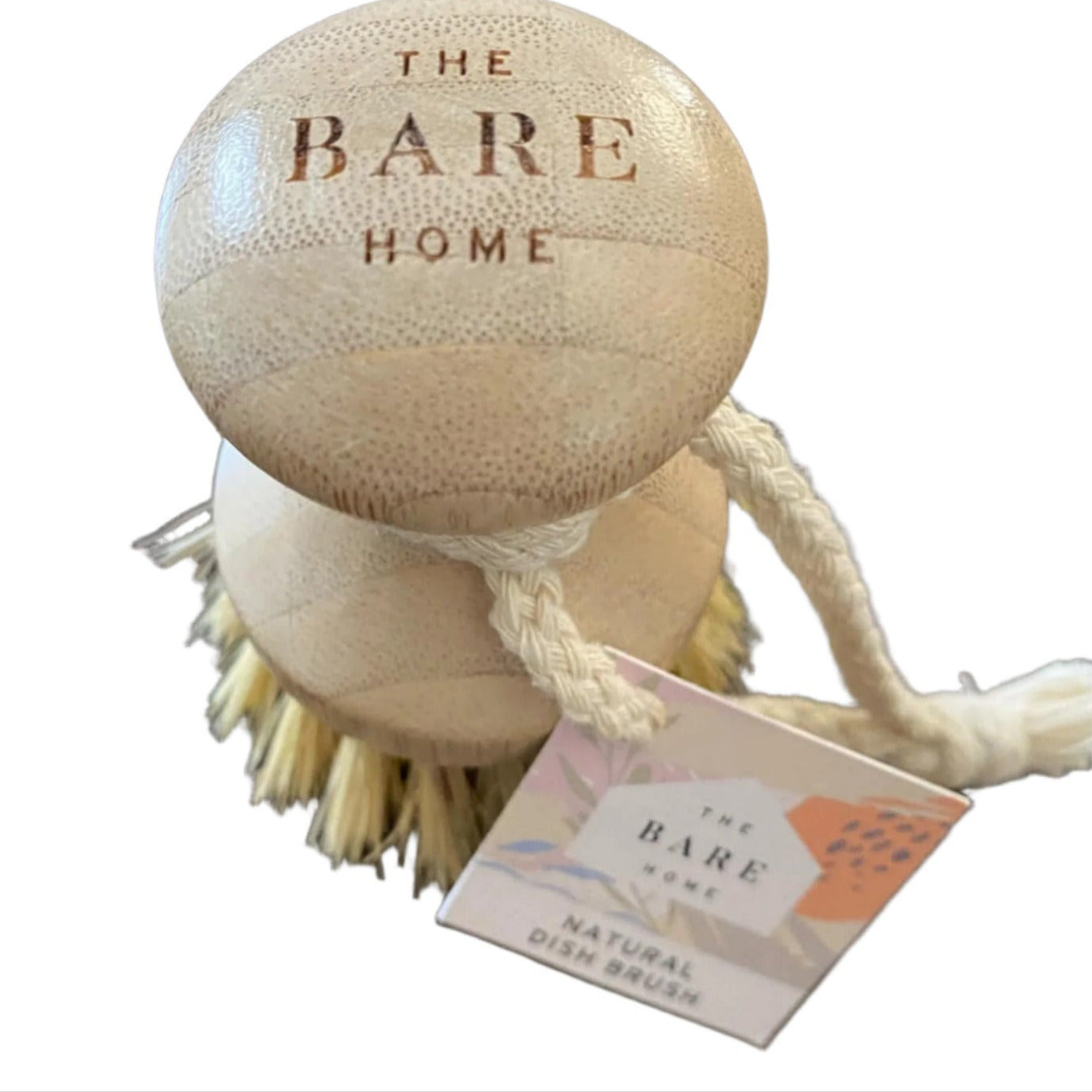 The Bare Home scrubber with a tag on a white surface