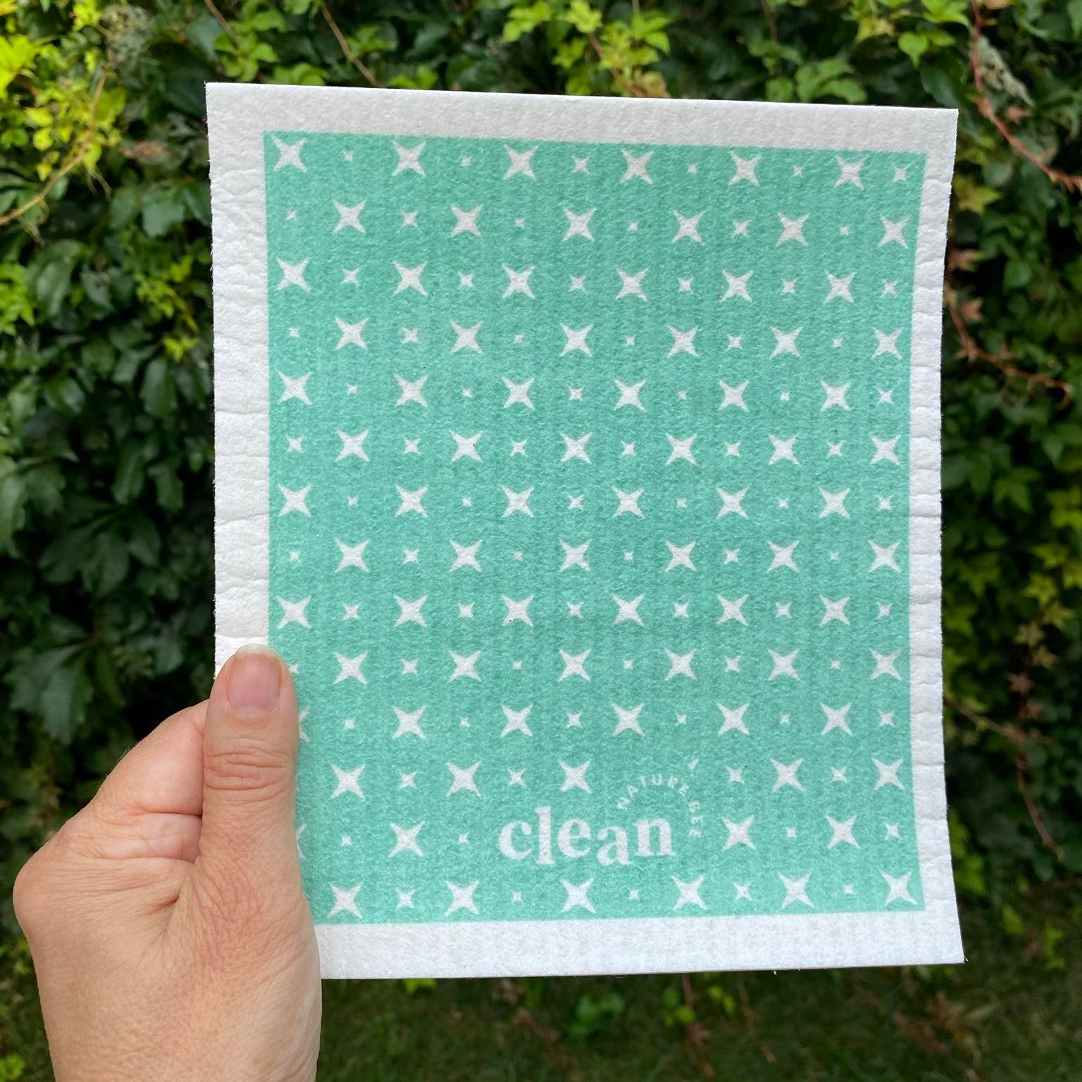 Swedish dishcloth in a pattern of white sparkles on a mint green background by Nature Bee replaces 17 paper towel rolls and absorbs up to 20x its weight in liquid