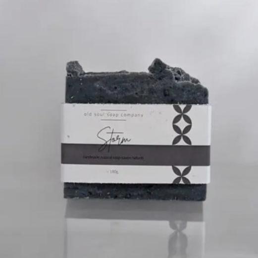 Lavender, charcoal and tea tree 180 g soap made in canada with the word storm on the label sits on a reflective grey background 